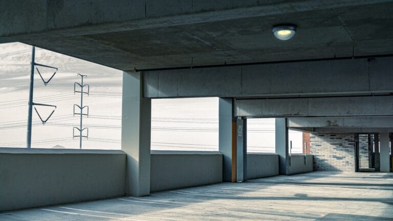 an empty parking garage with a sign on the wall
